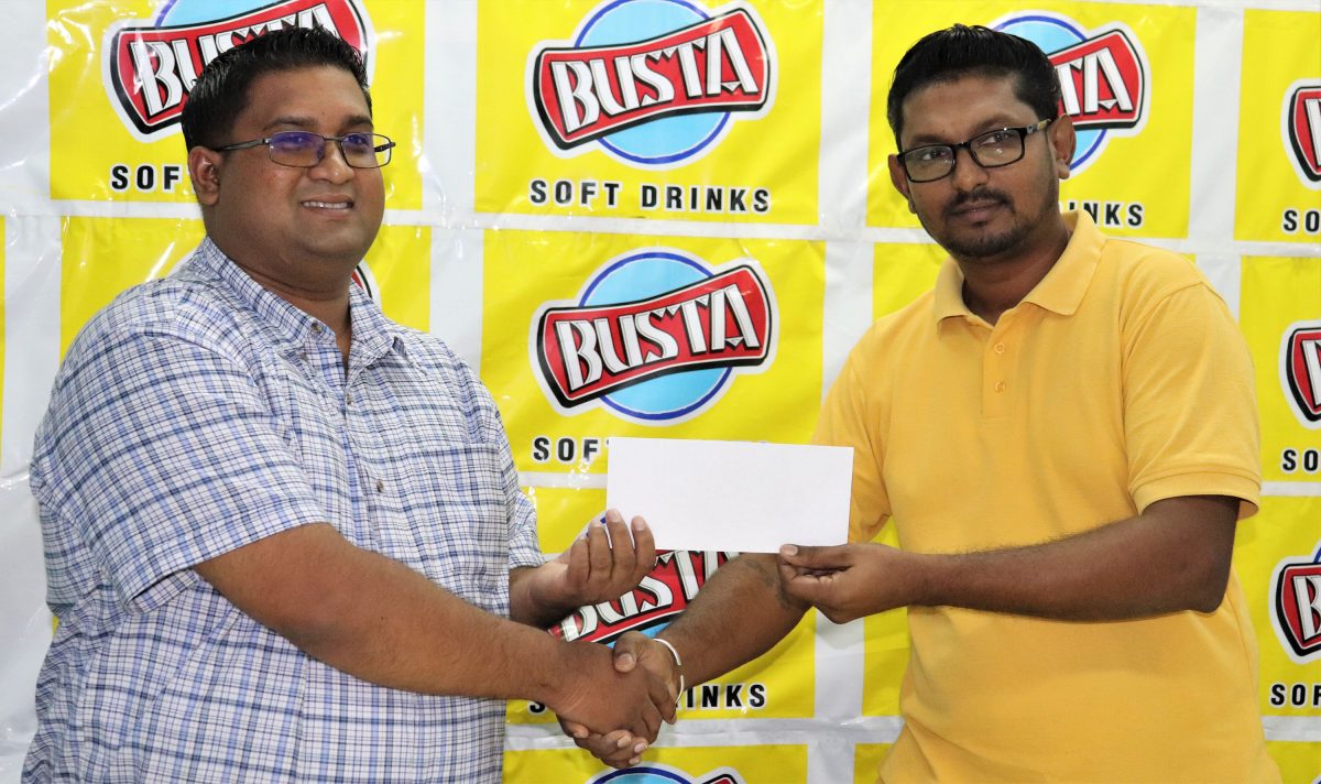 Busta Brand Manager, Raymond Govinda (left) presents the sponsorship cheque to Chandrapaul Tickaram, Secretary of the Busta Enterprise Sports Club (Romario Samaroo photo)

