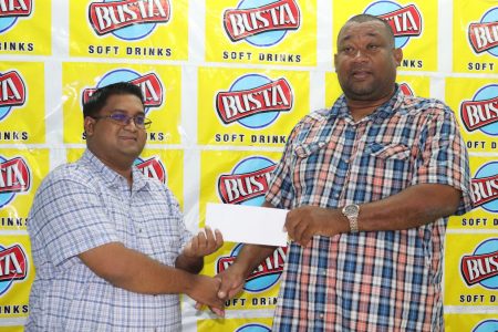 Rose Hall Town Youth and Sports Club CEO/Secretary, Hilbert Foster (right) receives the sponsorship from Guyana Beverage Company’s Brand Manager, Raymond Govinda (Romario Samaroo photo)
