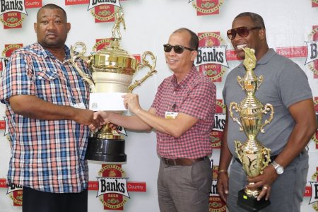President of the Berbice Cricket Board, Hilbert Foster (left) accepts the sponsorship cheque from Banks Beer Brand Manager, Brian Choo-Hen in the presence of Special Events Manager Mortimer Stewart (Romario Samaroo photo)
