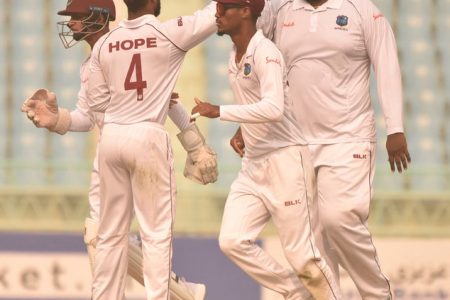 Off-spinner Rahkeem Cornwall (right) celebrates another wicket with teammates on the opening day of the one-off Test against Afghanistan yesterday. (Photo courtesy CWI Media