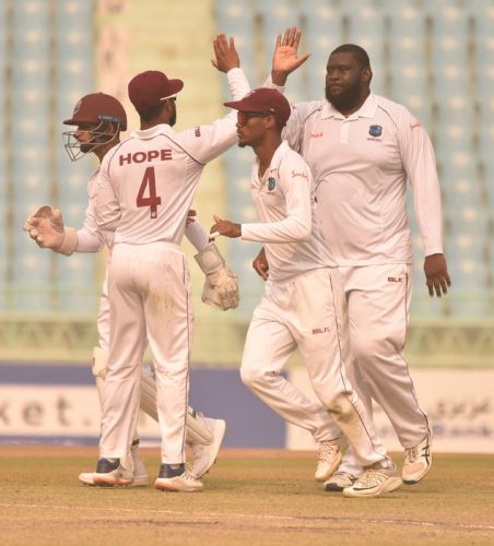 Off-spinner Rahkeem Cornwall (right) celebrates another wicket with teammates on the opening day of the one-off Test against Afghanistan yesterday. (Photo courtesy CWI Media