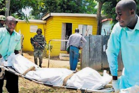 This file photo, taken on July 20, 2011, shows undertakers removing one of the bodies from the home in the Lauriston Housing Scheme, St Catherine, where gunmen hacked and then beheaded mother and daughter, Charmaine Rattray and Joyette Lynch. (Photo: Michael Gordon)