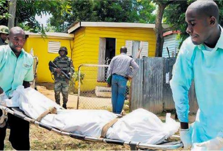 This file photo, taken on July 20, 2011, shows undertakers removing one of the bodies from the home in the Lauriston Housing Scheme, St Catherine, where gunmen hacked and then beheaded mother and daughter, Charmaine Rattray and Joyette Lynch. (Photo: Michael Gordon)