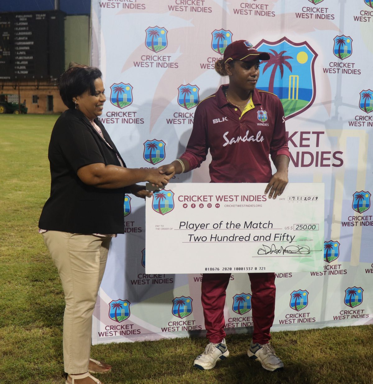 Hayley Matthews receives her player of the match award from Guyana Cricket Board Administrator, Savitri Persaud
