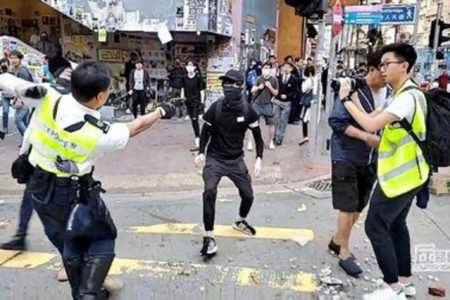A still image from a social media video shows a police officer aiming his gun at a protester in Sai Wan Ho, Hong Kong, China November 11, 2019. CUPID PRODUCER via REUTERS (reuters_tickers)