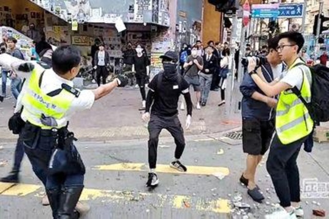 A still image from a social media video shows a police officer aiming his gun at a protester in Sai Wan Ho, Hong Kong, China November 11, 2019. CUPID PRODUCER via REUTERS (reuters_tickers)