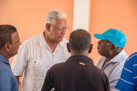 Minister of Agriculture, Noel Holder (second from left) in discussion with rice farmers (DPI photo)
