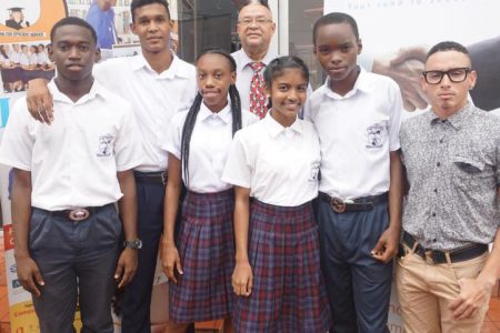 Director of The Business School, James Bovell (centre), some of the student-athletes and Teacher, Jonathan Fagundes pose for a photo outside the school recently
