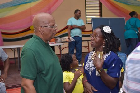 Minister of Finance,  Winston Jordan (left) interacts with a resident    (DPI photo)