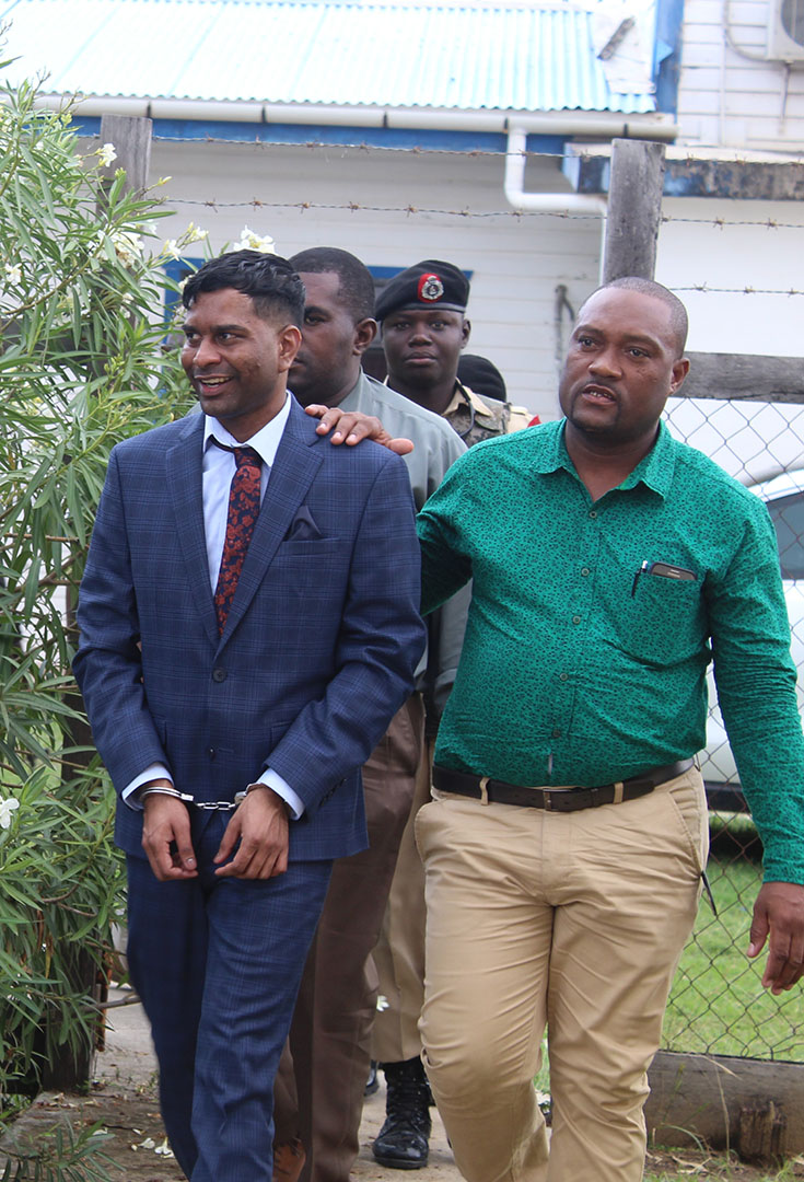 Marcus Brian Bisram (left) being led to the Whim court yesterday