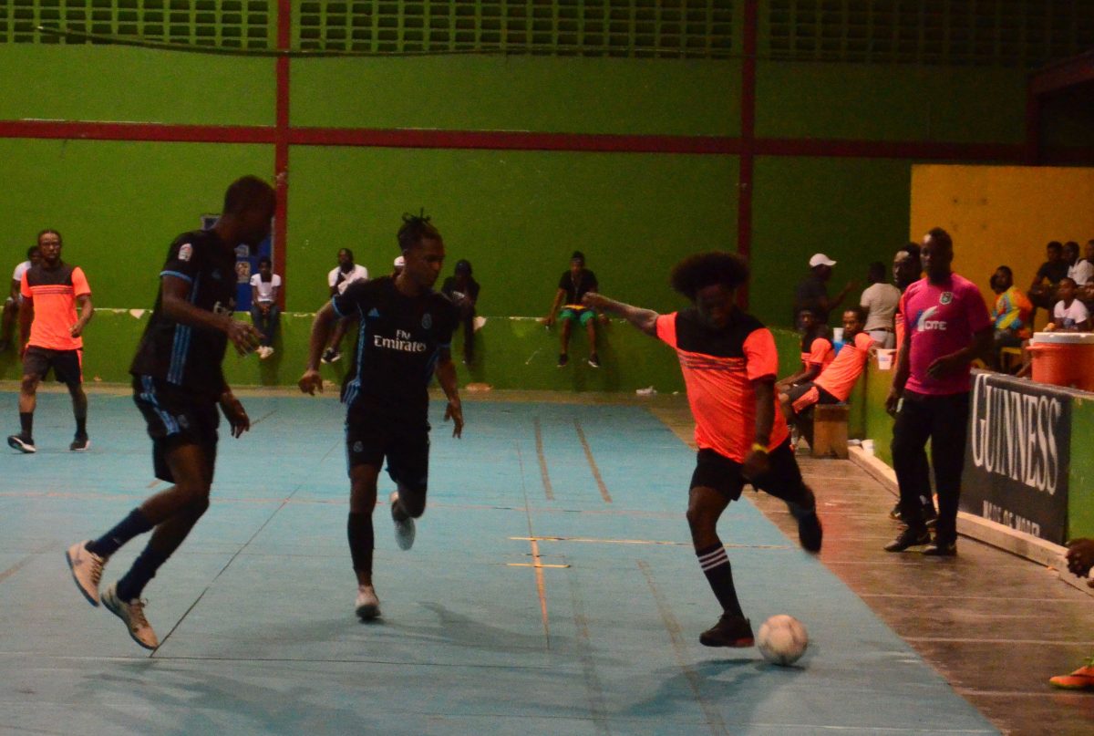 Nigel Denny [right] of Kingston attempting a shot while being pursued by two Sparta Boss players during their clash at the National Gymnasium.