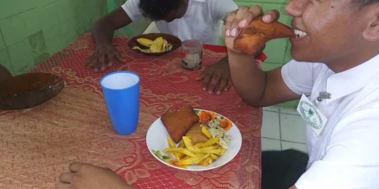 A student biting into a bake during his breakfast yesterday morning 