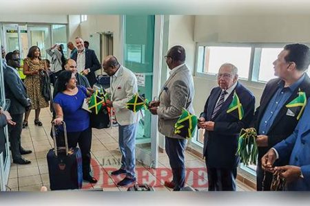 Minister of Tourism Edmund Bartlett (fourth right) welcomes an American Airlines passenger to the island last Thursday at Sangster International Airport in Montego Bay, St James, while (from third right) Director of Tourism Donovan White, United States Ambassador Donald Tapia and Montego Bay's Mayor Homer Davis, all of whom are bearing Jamaican flags, look on. (Photo: Anthony Lewis)