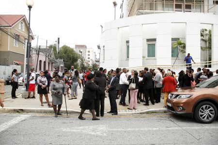 Workers from various offices gather at the corner of Queen Janelle Commissiong and St Vincent Streets, Port-of Spain, after buildings near the Government Campus Parkade were evacuated following an explosion at the facility yesterday.