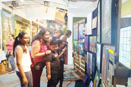 Persons viewing paintings at the event