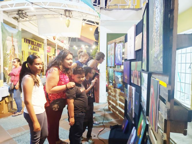 Persons viewing paintings at the event