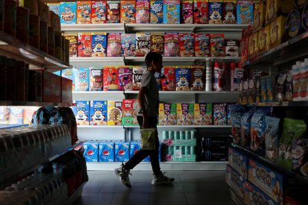 A childpasses in front of a shelf with cereal boxes at a "bodegon" named "Mini Walmart" in Puerto Cabello, Venezuela December 10, 2019. REUTERS/Manaure Quintero
