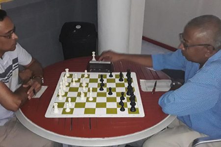 Shiv Nandalall (left) and Loris Nathoo play their game during the final Gaico Construction Grand Prix chess tournament which concluded last Sunday at the National Stadium, Providence. The encounter ended in a magnificent draw for Nathoo in a strange twist of miscalculation and fate. Nandalall stalemated the position with two pawns up, a king and a rook. A trick from Nathoo? (Photo by Rashad Hussein)