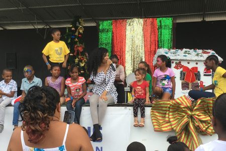 Spreading holiday joy: Singer Timeka Marshall sings with the orphans who were treated just over a week ago at the Ramps Logistics annual Christmas Treat at the National Park. The annual event was done in hopes of making the orphaned boys and girls of St. Ann’s Orphanage, the Sophia Care Centre, and the St John Bosco Boys’ Home happy during the festive season.
