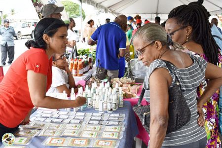 Ms Patrica Rampersad Agro-Processor interacting with shoppers at the last Farmer's Market day