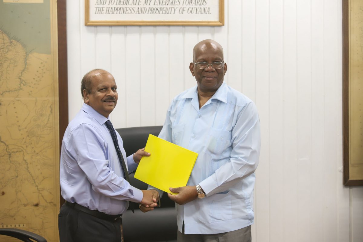 Governor of the Bank of Guyana Dr. Gobind Ganga displays the agreement with Finance Minister Winston Jordan after the signing. (Ministry of Finance photo) 