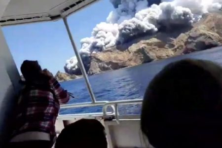 People on a boat react as smoke billows from the volcanic eruption of Whakaari, also known as White Island, New Zealand yesterday. (Reuters photo)