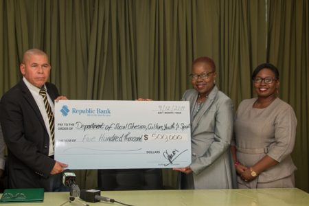 Minister of Social Cohesion Dr George Norton receives the cheque from Yonnette Greaves, of Republic Bank, who is accompanied by the bank’s Communications and Public Relations Officer Jonelle Dummett (DPI photo) 