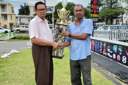 Proprietor of the Trophy Stall Ramesh Sunich, presents the champion jockey, champion trainer and runner up champion jockey trophies to Cecil Kennard yesterday for the traditional Boxing Day event.