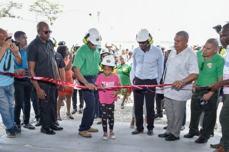 President David Granger assisting his granddaughter to cut the ribbon at the commissioning of the Bartica power plant. (Ministry of the Presidency photo)