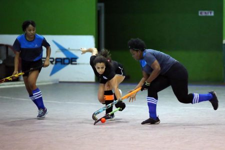 George United Captain Brianna Govia tackles Saints defender Rene James for possession in the Diamond Mineral Water Indoor Hockey Festival Saturday at the Cliff Anderson Sports Hall, Homestretch Avenue.
