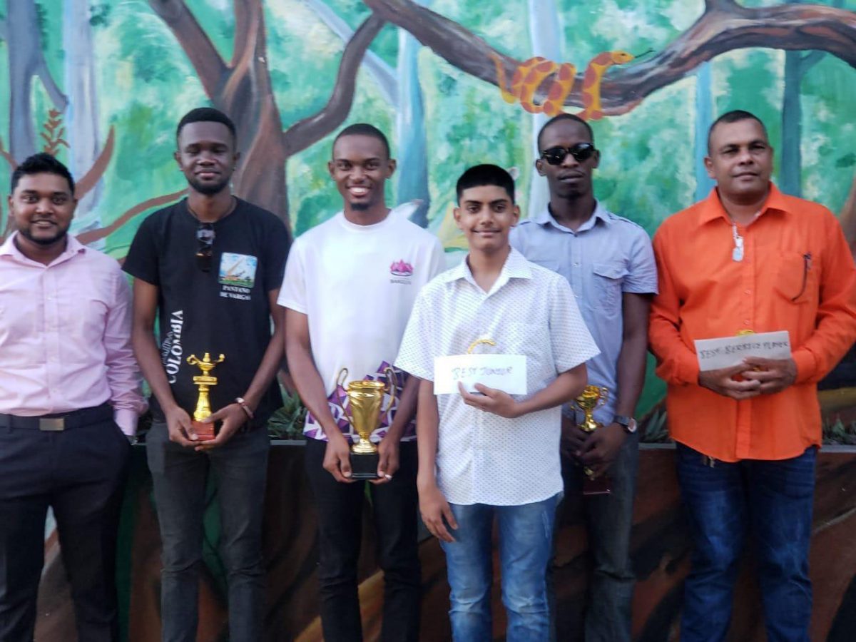 Manager of Outback Adventures Yuvindra Sookraj, sponsor of the Berbice Rapid Chess Tournament (left) with the winners of last Sunday’s Berbice Tournament. Standing next to Sookraj are (from left ) Davion Mars (third), Anthony Drayton (first), Omesh Dyal (Best Junior), Wendell Meusa (second) and Kriskal Persaud (Best Berbice Player).