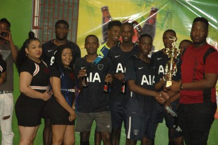 Adrian Aaron of Bent St collecting the championship trophy from Dragon Stout Brand Manager and tournament coordinator Jamal Baird [right] in the presence of his teammates following the conclusion of the inaugural Dragon Stout Community Cup at the National Gymnasium, Mandela Avenue
