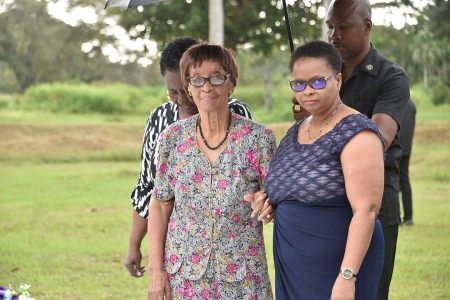 Gloria Hoyte (left) , sister of the late President Desmond Hoyte being assisted by Minister of Public Health and PNCR Chairperson, Volda Lawrence during the Commemorative Ceremony. (Ministry of the Presidency photo)