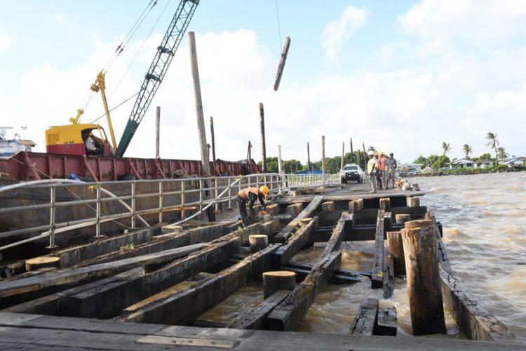 Workers effecting emergency repairs to the Leguan Stelling yesterday (Ministry of Public Infrastructure photo)
