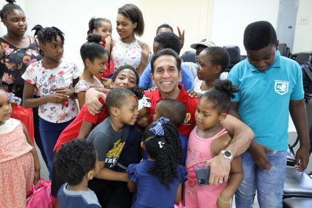 Attorney General and San Fernando West MP Faris Al-Rawi receives hugs from children of his constituency during his annual toy distribution drive at his office on Independence Avenue, San Fernando