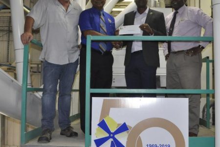 NAMILCO Managing Director Bert Sukhai [2nd from left], presents the cheque to GFF President Wayne Forde in the presence of Finance Director Fitzroy McLeod [left] and Chief Engineer Ralph Hemsing.