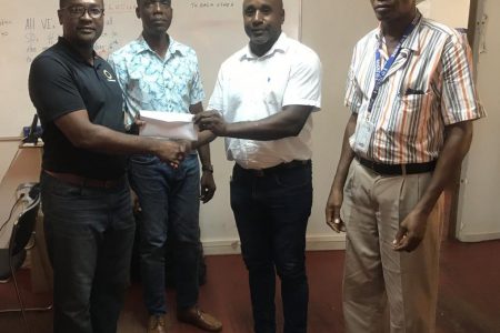 The Managing Director of Radar Security Services Adepemo Peters hands over the sponsorship cheque to GFF president Wayne Forde.
