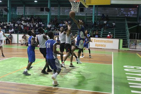 Action in the Marian Academy and St. Stanislaus College match at the Cliff Anderson Sports Hall in the Youth Basketball Guyana [YBG] Titan Bowl Championships.