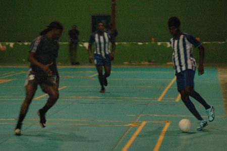 Trayon Bobb [right] of Rio All-Stars in the process of initiating an attack against Alexander Village at the National Gymnasium in the Dragon Stout Community Cup.