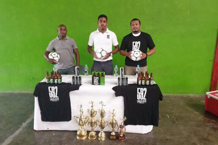 592 Beer Inter-Village Football Festival’ coordinator Eon Havercome [left], 592 Brand Manager Seweon McGarrell and Ansa McAl PRO Treiston Joseph pose for the cameras following the conclusion of the press briefing Friday.