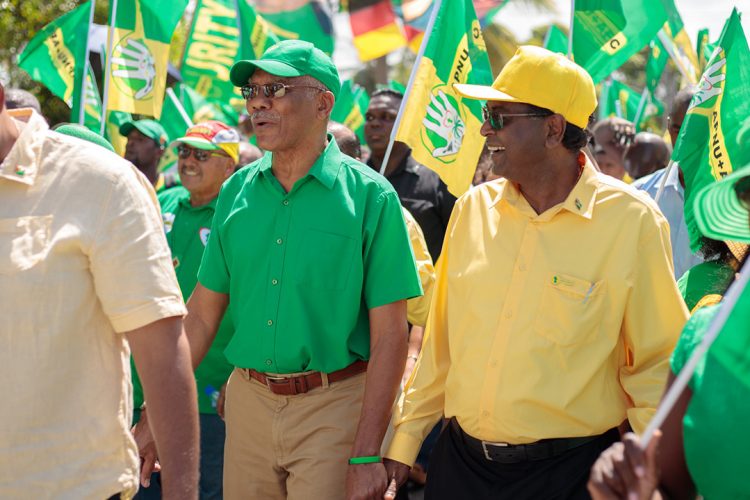 Running mates: President David Granger and Minister of Public Security Khemraj Ramjattan, who is also the APNU+AFC’s Prime Ministerial candidate, walked hand in hand as they led the governing coalition’s supporters yesterday to the Umana Yana, where they presented their lists of candidates for the upcoming elections.  (APNU+AFC photo) 