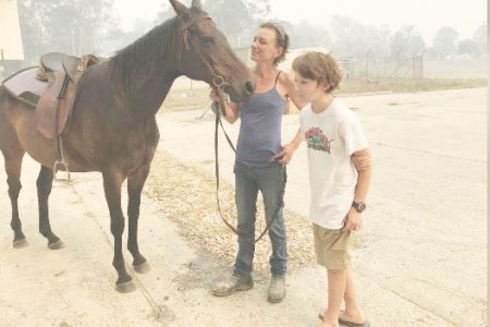 Bec Winter stands next to her son, Riley, and her horse Charmer, who she rode to safety through bushfires on New Year’s Eve, in Moruya, Australia yesterday. REUTERS/Jill Gralow