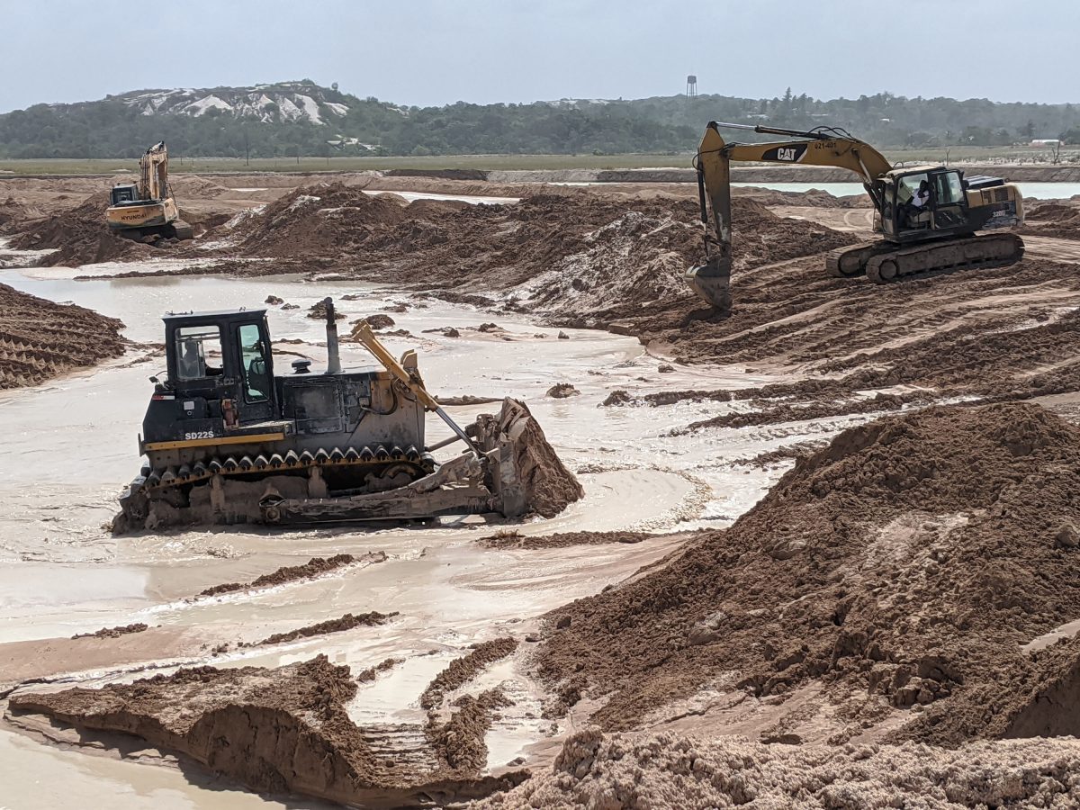 A bulldozer works to push heavy sediment out of the channel into which the slurry flows before moving further along, and entering  the cell at Stage 2