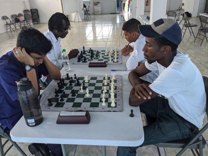 Ethan Lee (left) is a junior chess player who has been contesting the senior competitions during 2018. Here he faces Glenford Corlette who represented Guyana at a previous Chess Olympiad. Lee is a much-improved contender and is expected to perform creditably in the qualifier for the 2020 National Chess Championship. (Photo by John Lee) 
