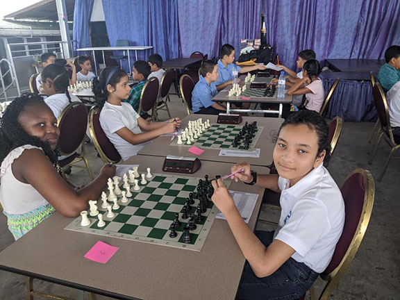 Harmony Dodson (left), a student at Mae’s Under-12, relaxes before the start of her game with Isabella Rodrigues of Marian Academy. The occasion was the Choco Moo-sponsored Under-12 chess tournament which was held last weekend at the School of the Nations. Participation by the girls in the tournament promised much for the future of chess in Guyana. (Photo by John Lee)