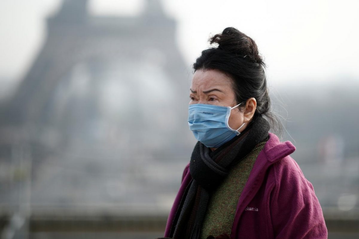 A woman wears a face mask on the Trocadero esplanade in front of the Eiffel Tower in Paris, France, January 25, 2020, as France confirmed three cases of the new coronavirus. REUTERS/Benoit Tessier