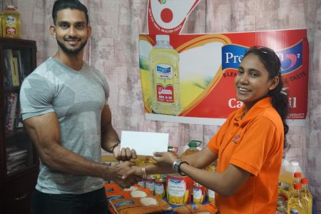 Dillon Mahadeo received a timely shot in the arm from Associated Packers Industry ahead of his next competition on February 9 at the National Park. Deputy CEO, Marissa Bujan handed over a sponsorship pact to Mahadeo yesterday. (Emmerson Campbell photo)
