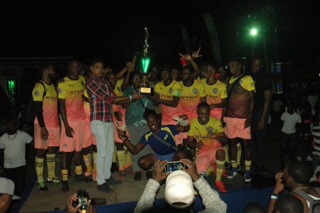 Friendship, the newly crowned 592 Beer Inter-Village Football Champion receiving their championship trophy from 592 Brand Manager Seweon McGarrell following their victory at the Golden Grove Community Centre ground
