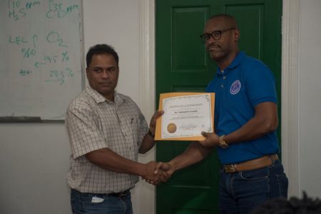 Trinidad-based Business Crisis consultant, Garth Vincent (right), presenting a certificate to one of the participants. (DPI photo)
