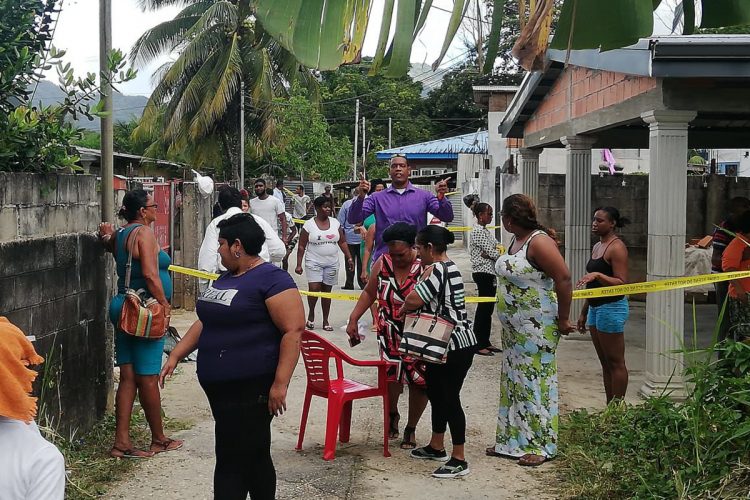 Stunned family and friends of the victims near the house where the killings happened. Photo: Jermaine Cruickshank.